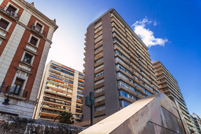 Low angle view of modern buildings against blue sky