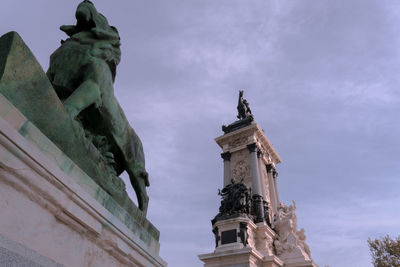 Low angle view of statue of historic building against sky