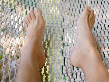 Low section of person resting on hammock