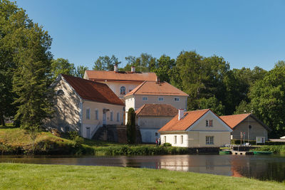 Houses by lake and buildings against sky