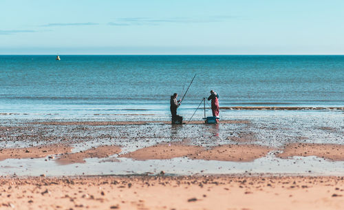 People on beach against sky