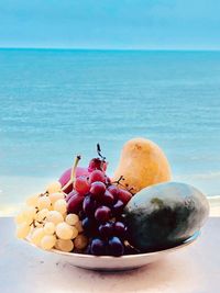 Close-up of fruits in container on table at beach