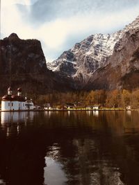 Scenic view of lake by mountains against sky