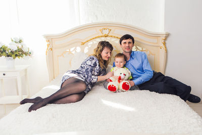 Full length of mother and girl sitting at home