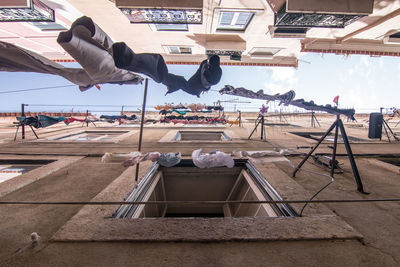 Directly below view of clothesline amidst building