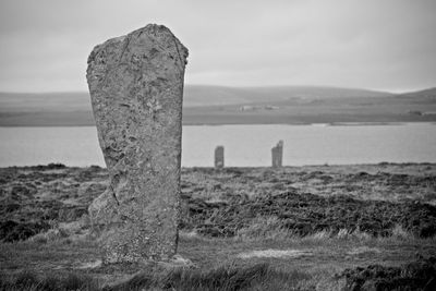 Old ruin on field by sea against sky