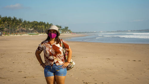 Full length of young woman standing on beach