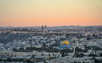 Aerial view of buildings in city at sunset