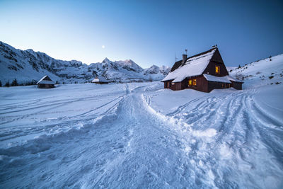 Snow covered land and mountains against sky