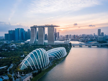 View of city at waterfront against cloudy sky