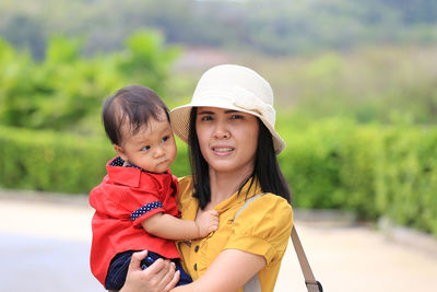 Portrait of mother with son standing outdoors