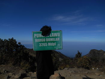 Information sign on rock against sky