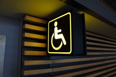 Close-up of yellow sign on steps at subway station