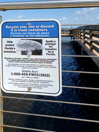 Close-up of information sign by sea