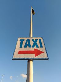 Low angle view of road sign against blue sky