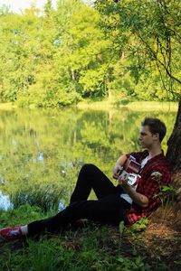 Man playing guitar on lake