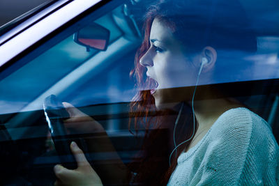 Side view of woman with mouth open driving car