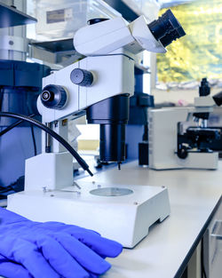 Cropped image of scientist by microscope in laboratory