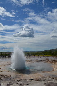 Scenic view of waves breaking against sky