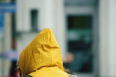 Rear view of person with yellow rain cap 
