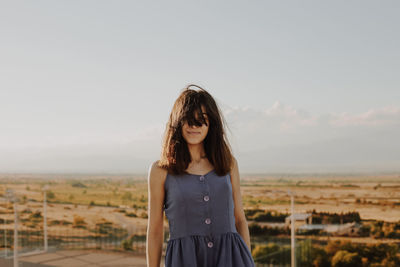 Mature woman standing on terrace against sky