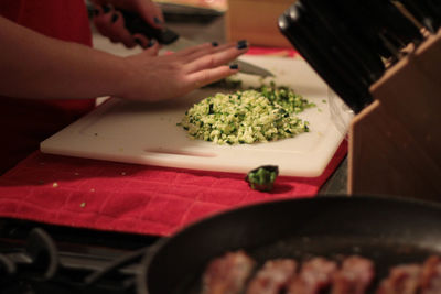 Woman chopping vegetable on cutting board