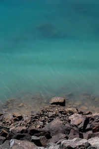 Rocks on shore against blue sky