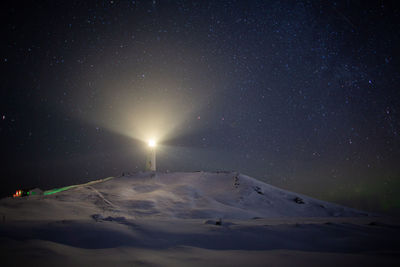 Scenic view of snowcapped mountains against sky at night