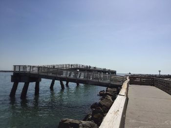 Pier on sea against clear sky