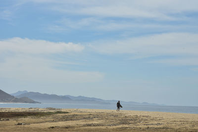 Surfer on seashore pacific coast beach