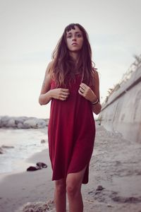 Portrait of beautiful woman standing against sky