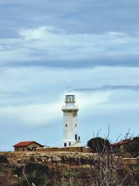 Lighthouse by sea against sky