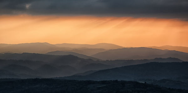 Scenic view of mountains against sky at sunset