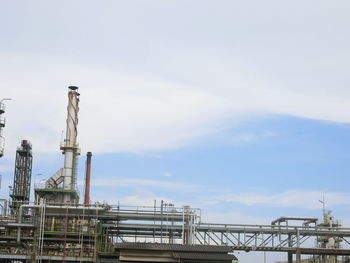 Cranes at commercial dock against sky