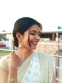 Close-up of smiling beautiful woman wearing earring and sari while standing outdoors