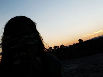 Silhouette woman against sky during sunset