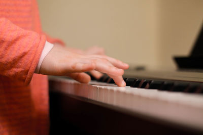 Cropped hands of boy playing piano