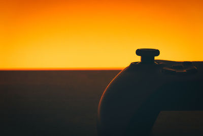 Close-up of silhouette tap against clear sky during sunset