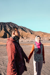 Woman standing on desert against clear sky