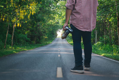 Rear view of man walking on road
