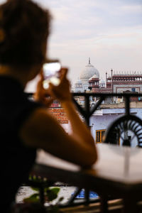 Woman photographing taj mahal