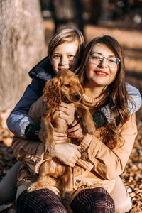 Pet care advice for autumn. happy family mother and teen boy son walking and having fun with cocker