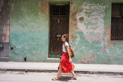 Full length of woman standing against building