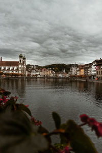 River by buildings against sky
