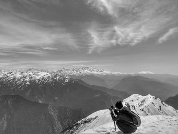 Woman on snowcapped mountain against sky