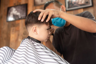 Close-up of boy getting haircut