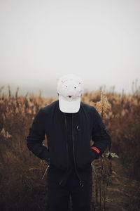 Man standing on field against sky