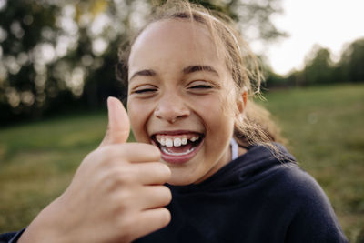 Cheerful girl showing thumbs up gesture