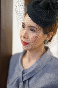 Close-up of woman wearing veiled hat 