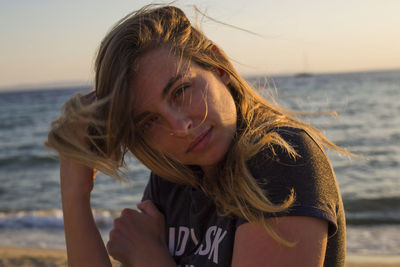 Portrait of woman at beach against sky